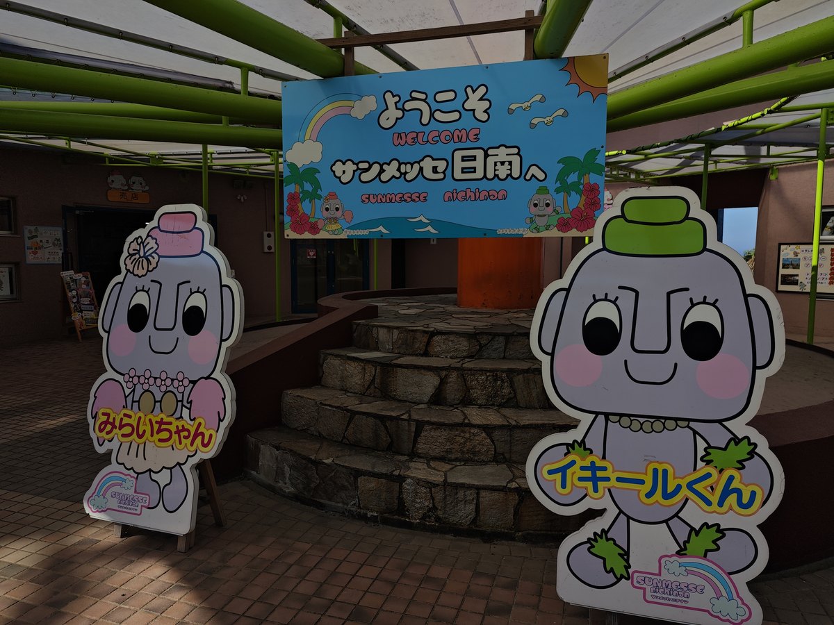 サンメッセ日南の入口の「ようこそ」の看板とキャラクター