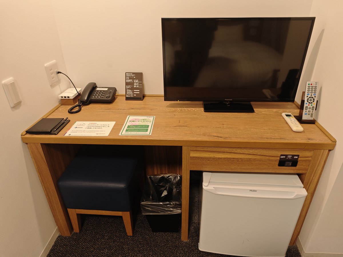 ドーミーイン宮崎の客室のデスク。テレビ、電話、冷蔵庫