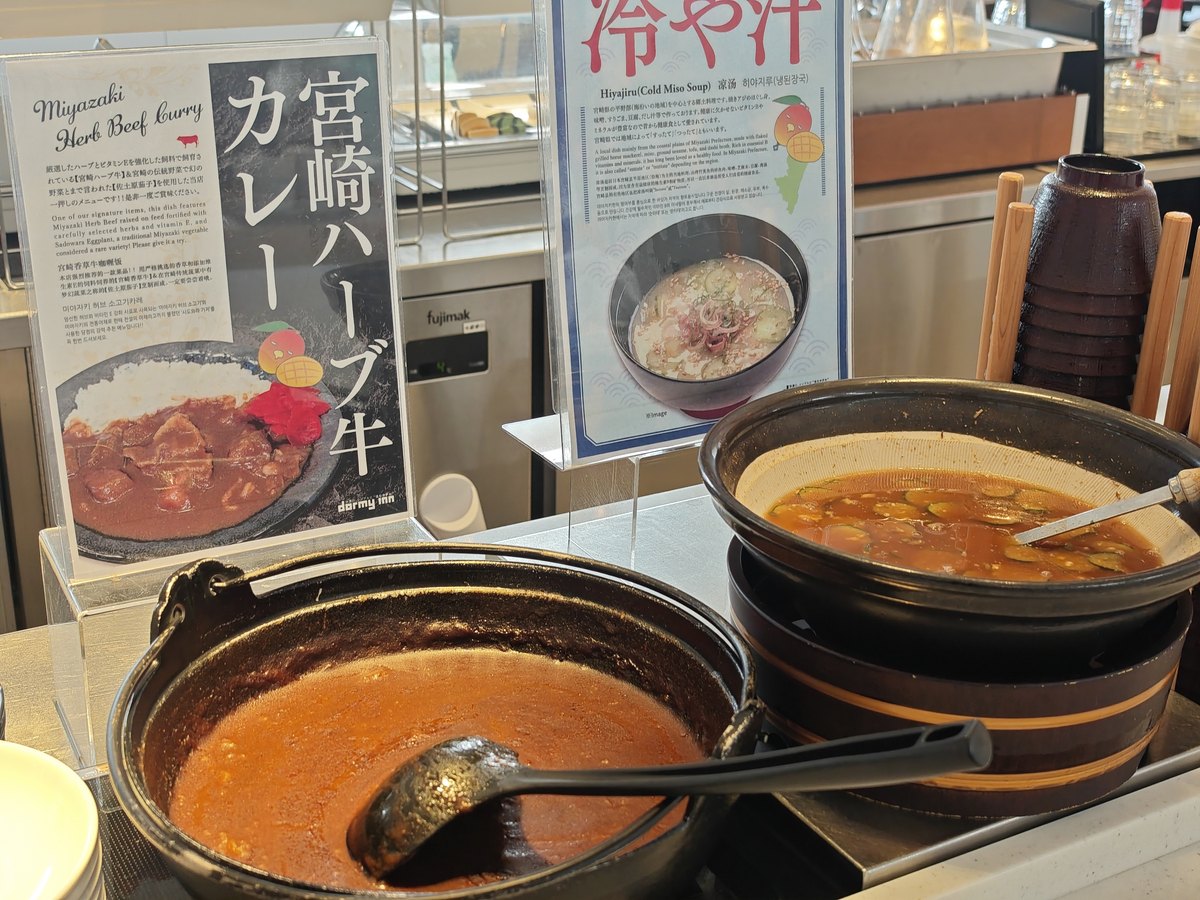 ドーミーイン宮崎の朝食会場。冷や汁と宮崎ハーブ牛カレーのメニュー札と鍋