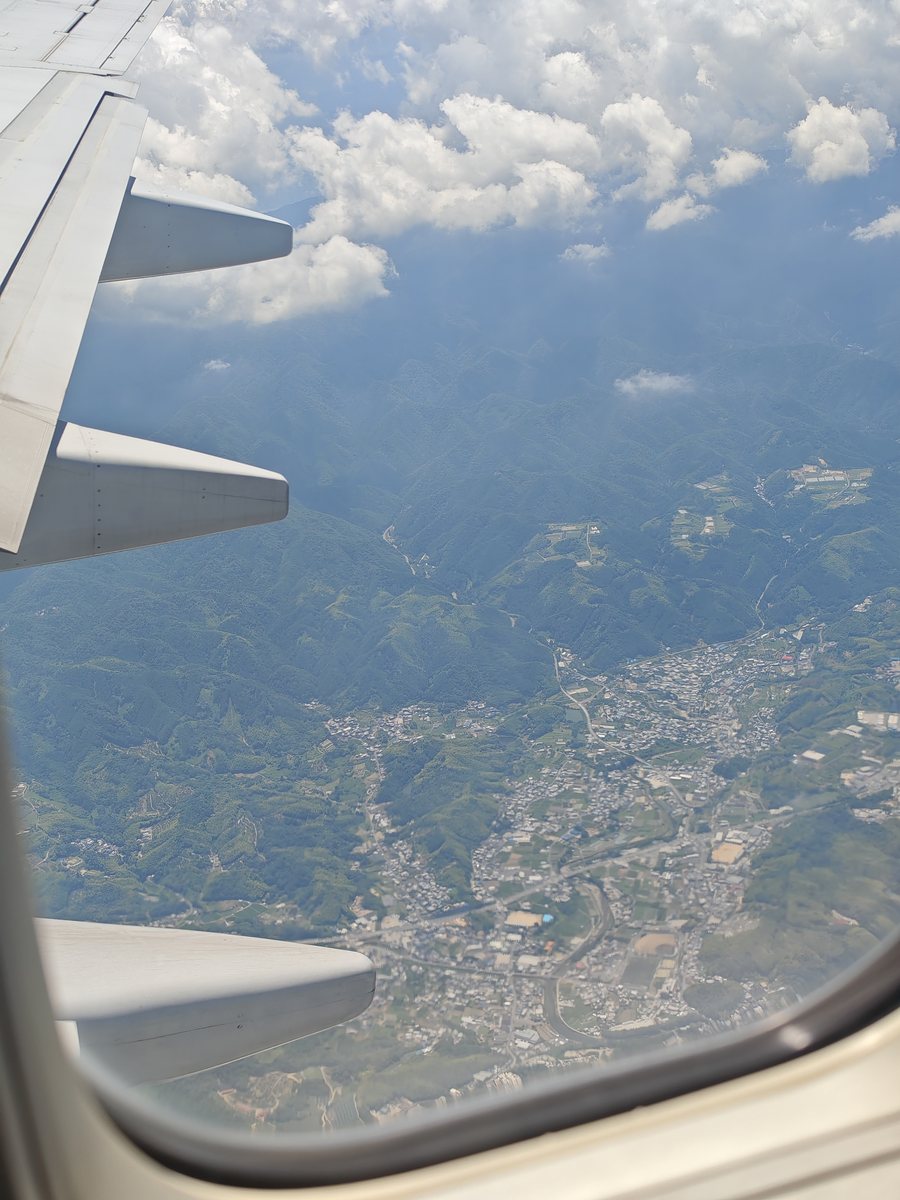 機内の窓から見た山あいの町